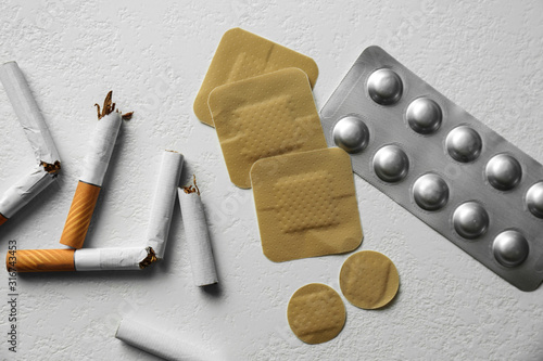 Quadro em tela Nicotine patches, pills and broken cigarettes on white background, flat lay