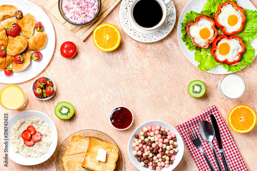 Continental breakfast with cereal, fried eggs, croissants, fruits and drinks on textured table, copy space. Table top with various healthy snacks and foods on rustic background