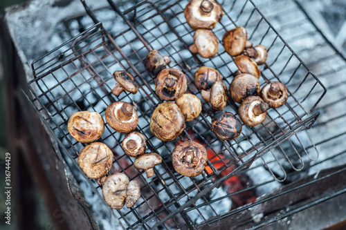 Grilled mushrooms. BBQ grill and burning coals, cooking outdoors