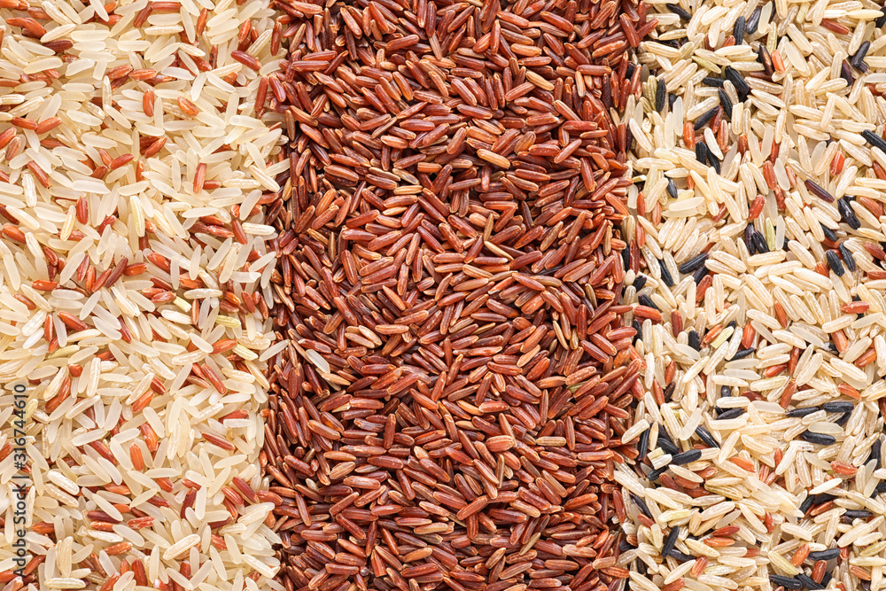 Mix of different brown rice as background, top view