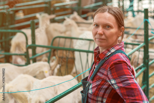 Fotografie Female farmer at goat raising and breeding farm
