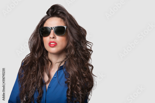 Wallpaper Mural Portrait of an attractive young woman wearing sunglasses against gray background Torontodigital.ca