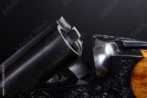 Double-barreled gun on black background.