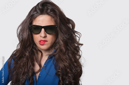 Wallpaper Mural Portrait of sensuous young woman wearing sunglasses while biting lip over gray background Torontodigital.ca