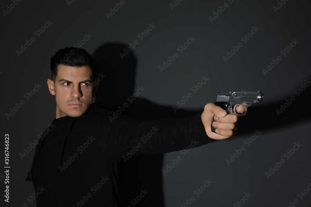 Professional killer with gun on black background Professional killer with gun on black background