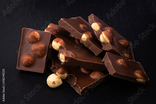 milk chocolate pieces with nuts on a dark background