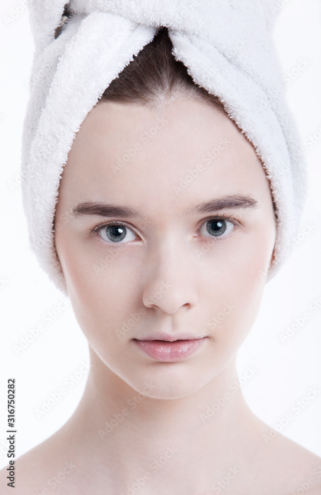 Portrait of young woman with towel wrapped around her head against white background Portrait of young woman with towel wrapped around her head against white background