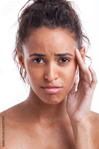 Portrait of young Mixed Race woman suffering from headache against white background