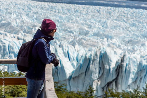 Female tourist viewing a glacier from a voewpoint. Perito moreno, Argentina