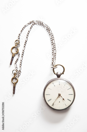 Old-fashioned pocket watch over white background