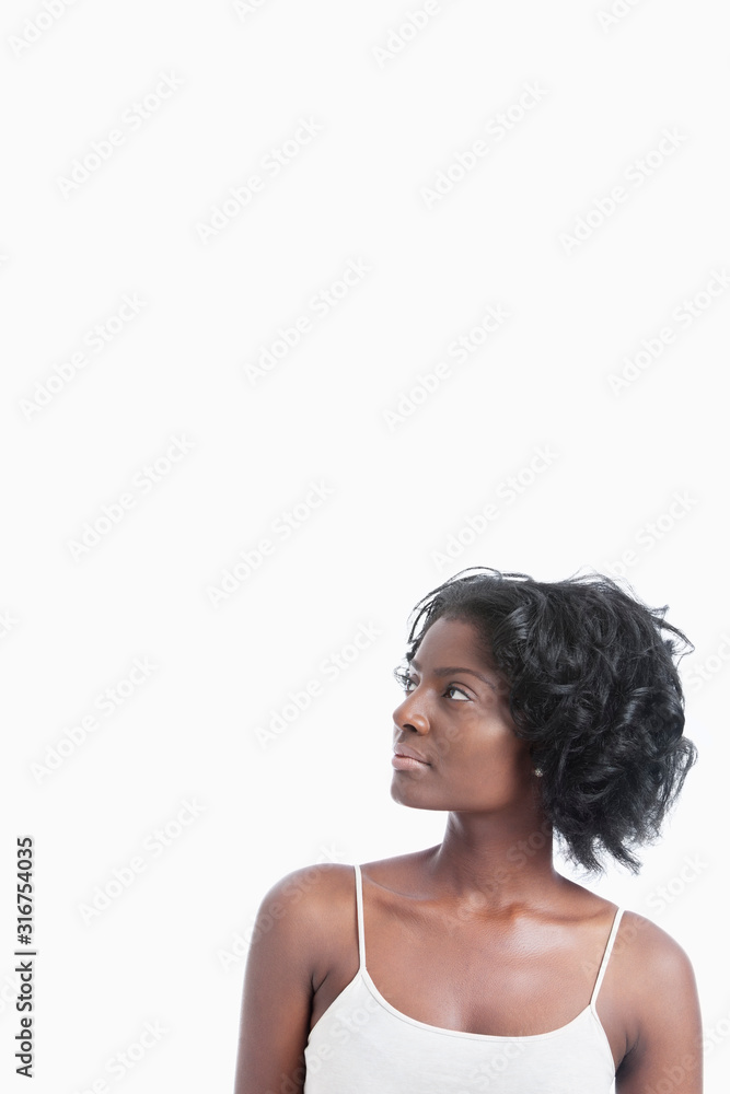 African American young woman looking up against white background African American young woman looking up against white background