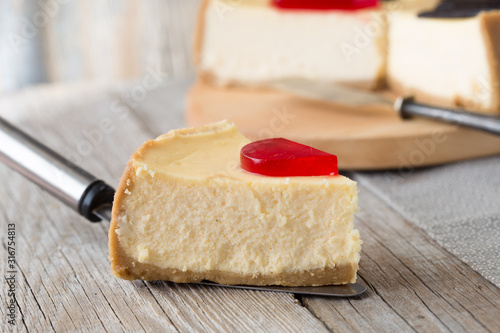 Delicious slice of new york cheesecake on  grey background, isolated. Sweet and tasty food, coffee break concep. Classic american dessert.