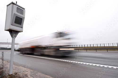 Police radar for measuring speed of passing vehicles stands on highway. Radar installed on roadside to control speed limit. Speed control, radar on the sideline controls speed of moving cars
