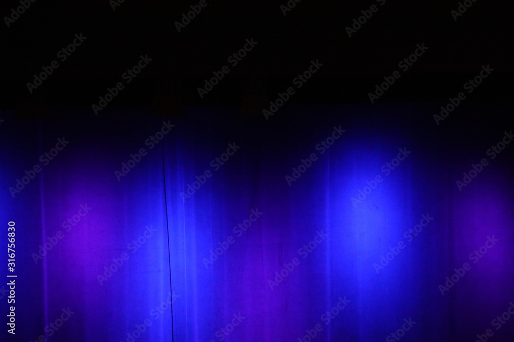 blaues Licht auf einem Vorhang auf einer Bühne