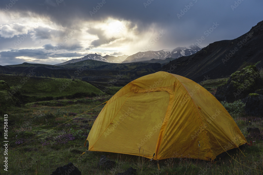 Yellow camping tent in an open moss field during sunset. Shot on adventure in Icelandic highlands