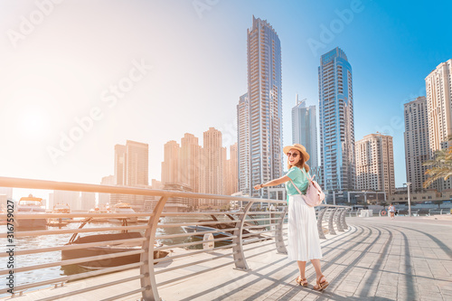 Photography Cheerful asian traveler girl walking on a promenade in Dubai Marina district