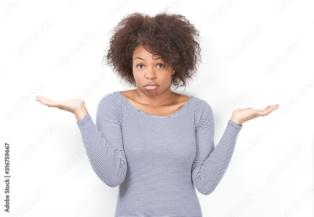Portrait of confused African American young woman shrugging against white background Portrait of confused African American young woman shrugging against white background