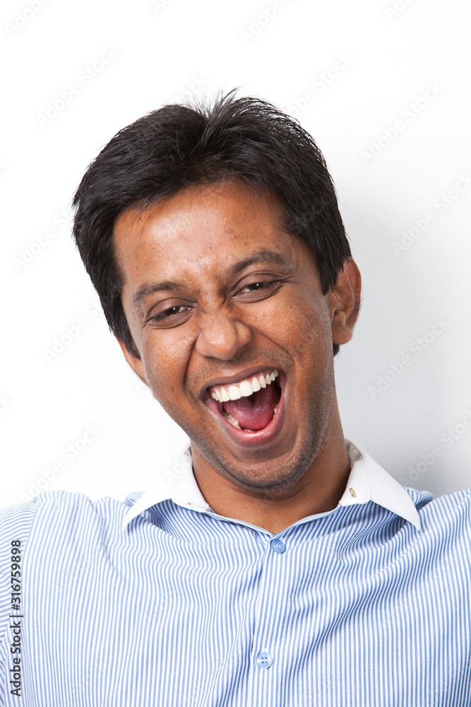 Fototapeta premium Portrait of cheerful young Indian man against white background