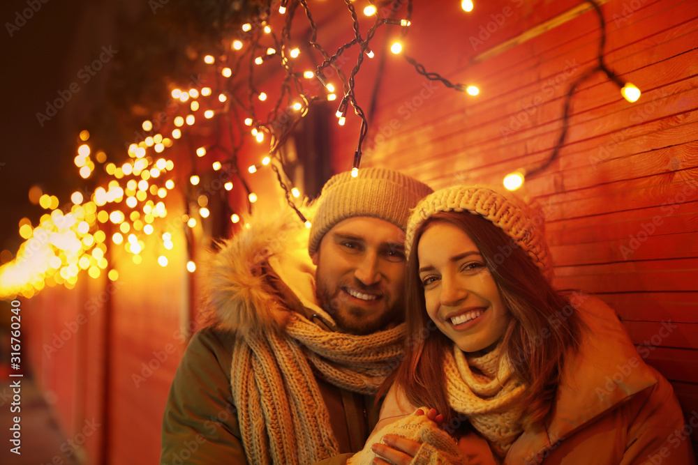 Happy couple spending time at Christmas fair Happy couple spending time at Christmas fair