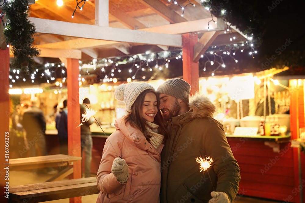 Happy couple spending time at Christmas fair