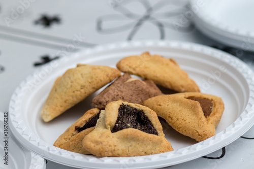 ozen haman, Jewish holiday pastry, for Purim holiday. Crispy dough stuffed with chocolate, halva or poppy flavored stuffing. Isolated on a blurry background