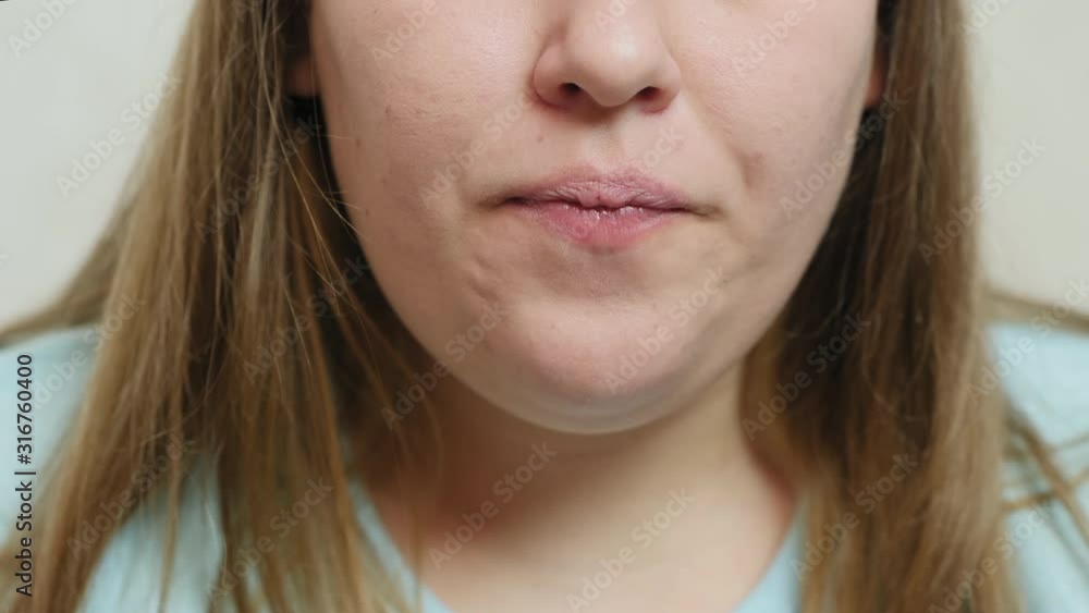 Close-up of overweight girl drinks cola from a tubule and eats chips, slow-motion shot Close-up of overweight girl drinks cola from a tubule and eats chips, slow-motion shot