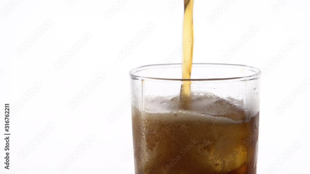 Cold refreshing cola pouring into a glass with ice on white background with space for text. Icy beverage of cool drink with caffeine Cold refreshing cola pouring into a glass with ice on white background with space for text. Icy beverage of cool drink with caffeine