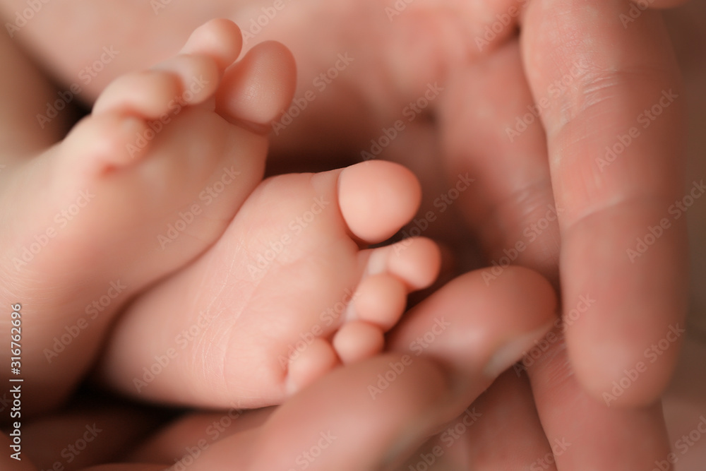 Heels of a newborn baby in the hands of a man Heels of a newborn baby in the hands of a man