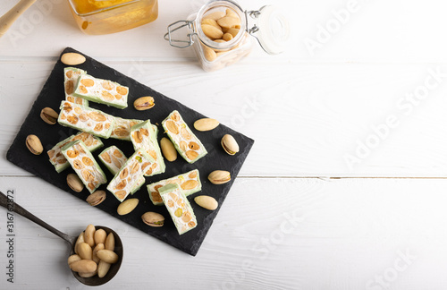 Homemade organic pistachio nougat on a white background top view.
