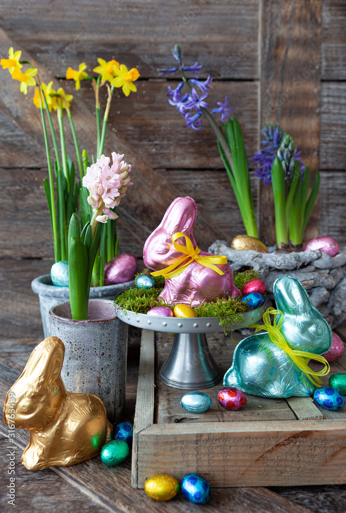 Fototapeta premium Bunte Schokohasen und Blumen