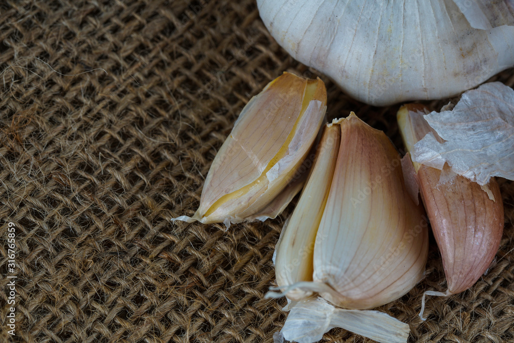 Close up of garlic cloves over brown sack background.