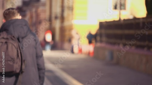 Wallpaper Mural Handsome, attractive young man is strolling through the street having his black backpack. He is going out of the focus. Copy space. Action. Animation. 4K. Torontodigital.ca