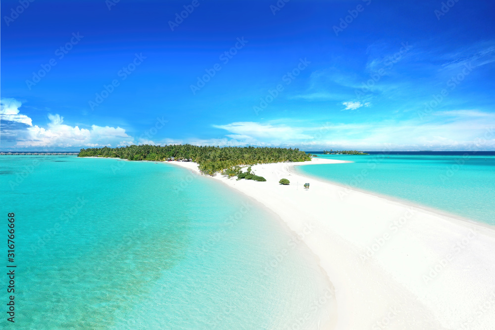 Summer background for vacation. Beautiful sandbar in turquoise ocean against blue sky with white clouds. Landscape beach aerial view of Maldives island.