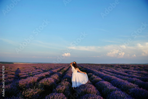 back view of a woman in white dress in lavender field