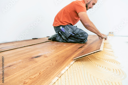 Wallpaper Mural Craftsman is laying parquet flooring in a modern new building Torontodigital.ca