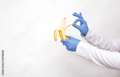 Dotkor holds a banana in his hands and peels. The concept of a surgical operation to dissect the frenum of the foreskin in men, circumcision of the foreskin, phimosis, copy space photo