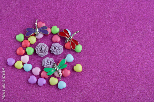 Colorful hearts,paper roses and dragonflies on a pink background.