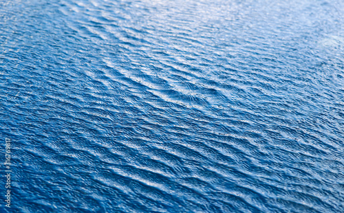 Water waves surface background. Aqua background texture. Abstract water ripples selective focus. Design element for banner and artwork