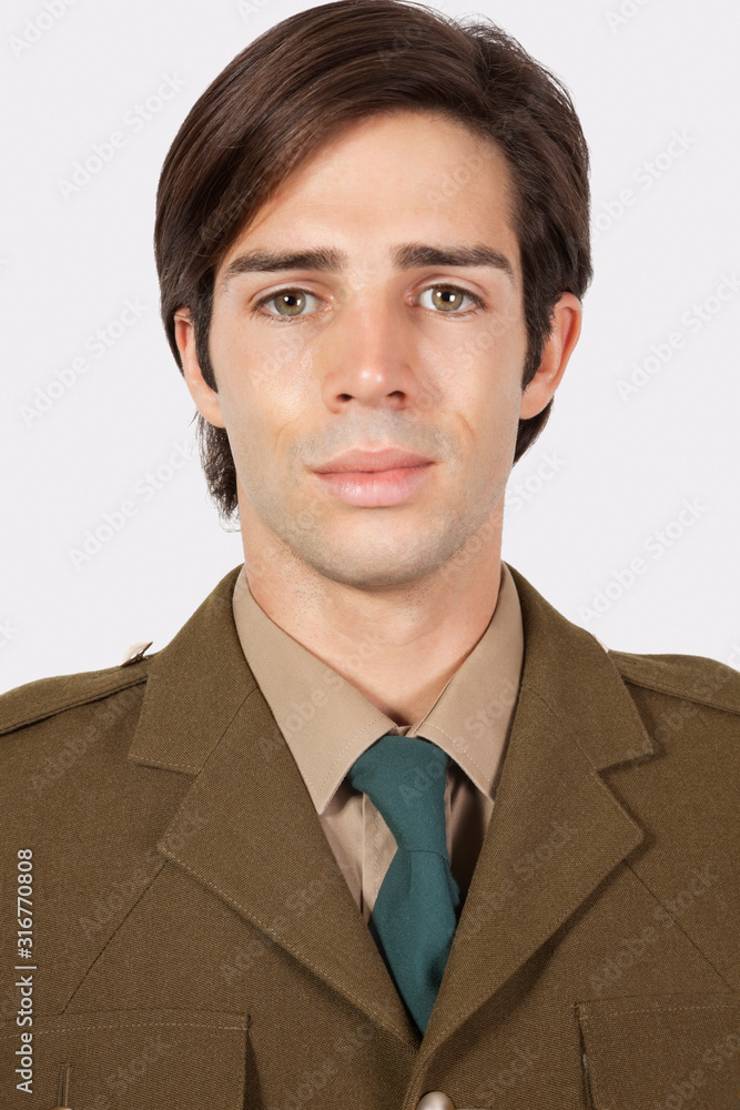 Portrait of young man in military uniform against gray background Portrait of young man in military uniform against gray background