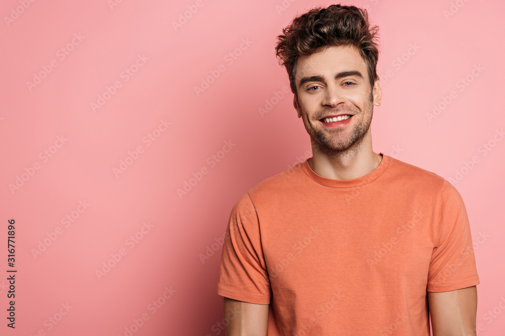 happy, handsome young man smiling at camera on pink background happy, handsome young man smiling at camera on pink background