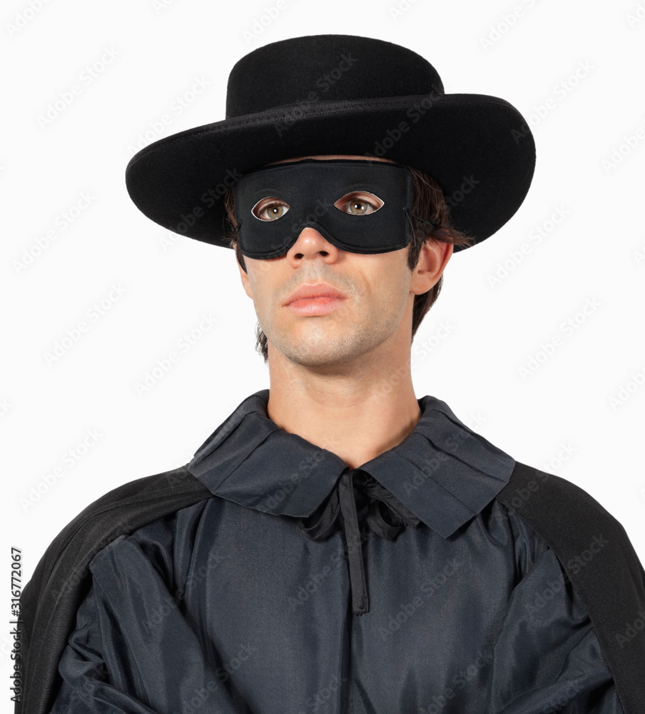 Thoughtful young man dressed as Zorro against gray background Thoughtful young man dressed as Zorro against gray background