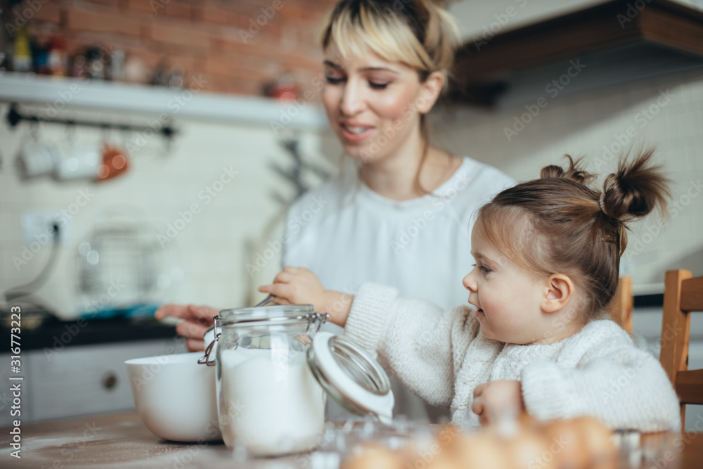 Mother and daughter baking cookies in their kitchen Mother and daughter baking cookies in their kitchen