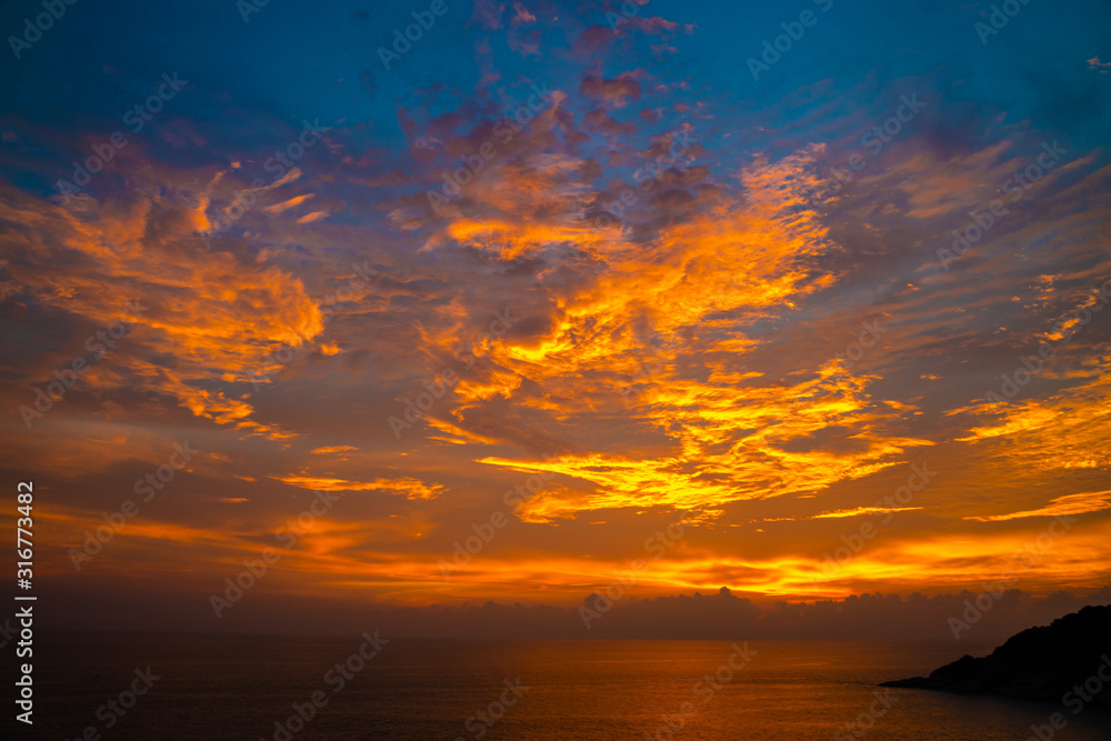 Colourful majestic sunset sky with cloud on sea shore wide angel len