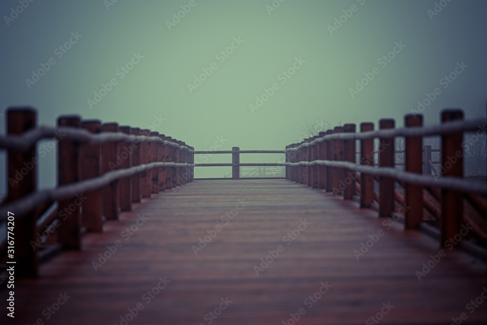 not a big wooden bridge on the lake with heavy fog