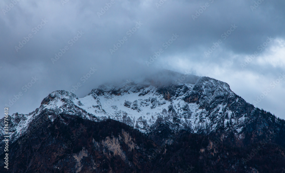 winter time snowy lonely mountain peak gorgeous picturesque moody and foggy scenic view landscape background