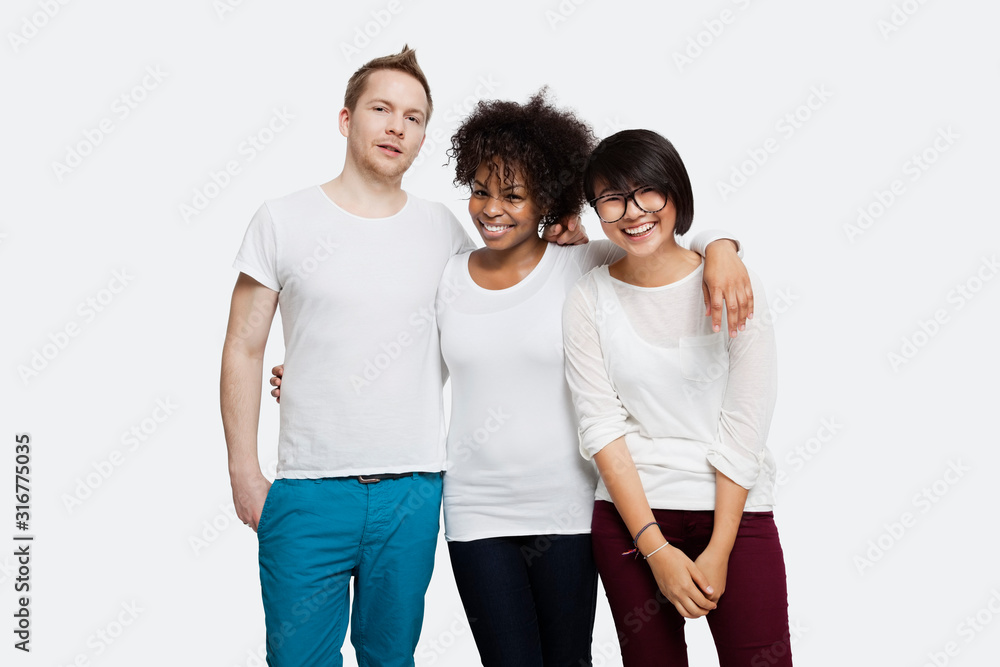 Portrait of happy multi-ethnic friends in casuals with arm around each other over white background Portrait of happy multi-ethnic friends in casuals with arm around each other over white background