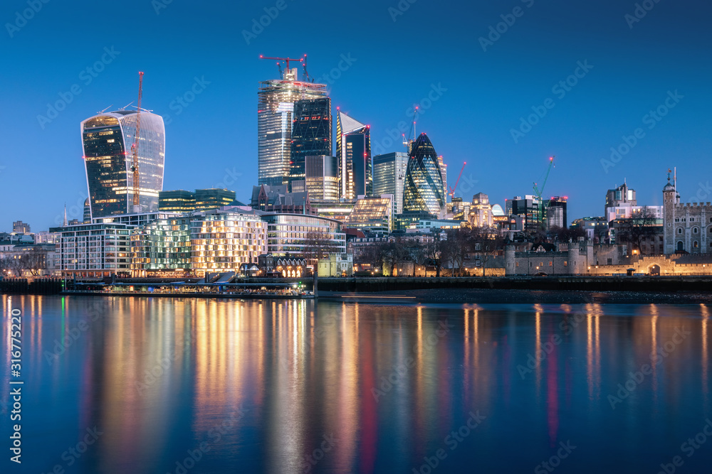 London skyscraper skyline with reflection in Thames river during twilight in London, UK