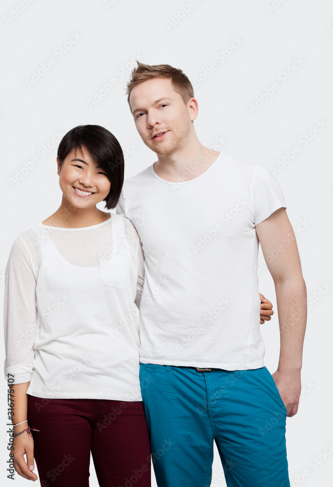 Portrait of young couple in casuals smiling over white background Portrait of young couple in casuals smiling over white background