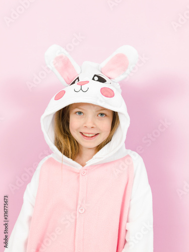 pretty blonde girl with cozy rabbit costume is posing in the studio and is happy