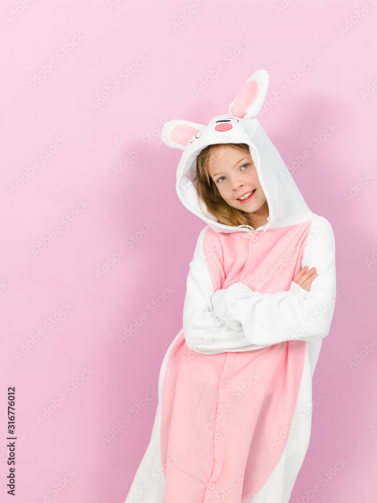 pretty blonde girl with cozy rabbit costume is posing in the studio and is happy